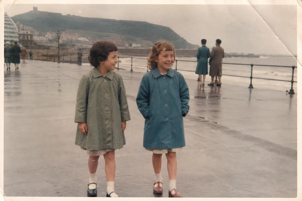 Illustrative vintage photograph of two sisters on a seaside promenade after rain